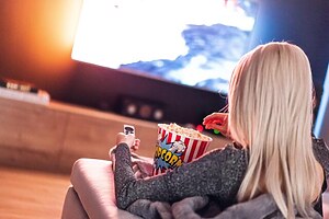 (Beispielbild) Popcorn Mädchen Fernseher Streaming Lebensmittel